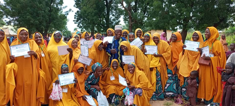 Women proudly holding certificates of participation